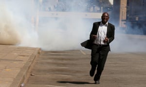 A man flees from teargas during clashes in Harare.