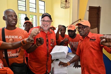 people in orange shirts hold up their fists
