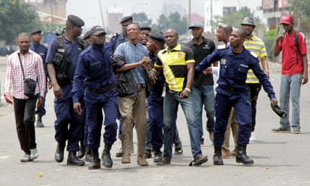 Congolese policemen detain opposition activists in Kinshasa.