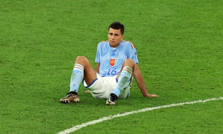 A dejected-looking Rodri sits on the pitch after Spain are knocked out on penalties by Morocco