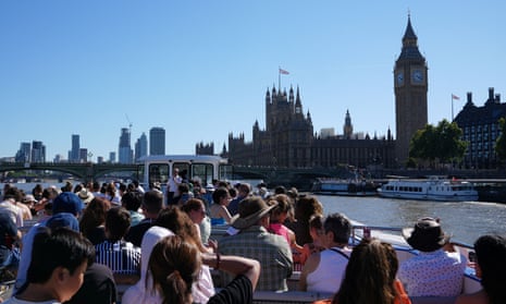 Tourists take a riverside cruise on the Thames beside the Houses of Parliament.