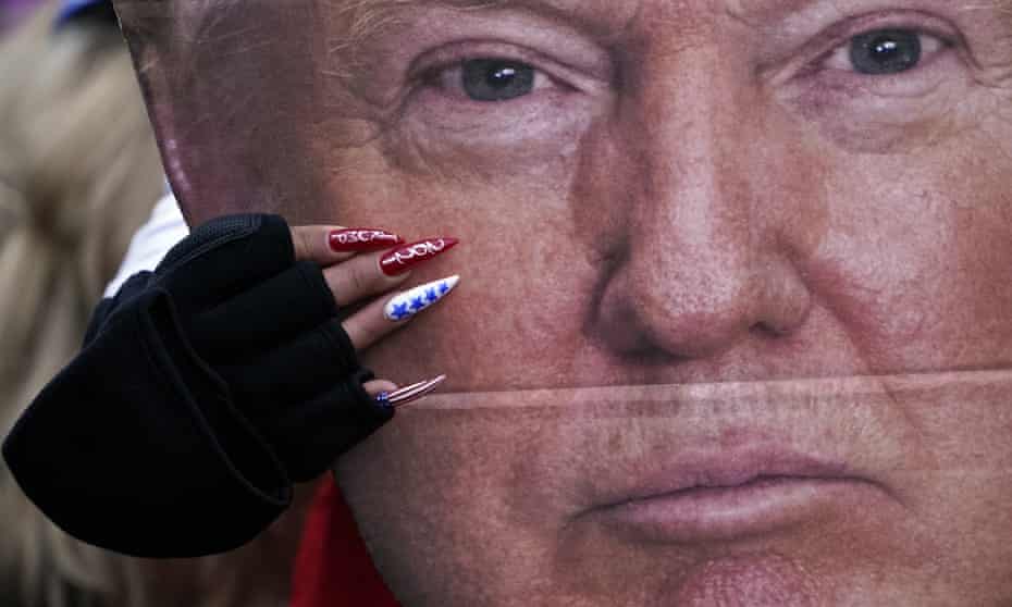 A woman holds a cutout of  Donald Trump's face – in Washington on 6 January 2021.