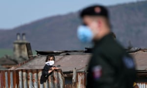 A police officer patrols outside a Roma settlement in Krompachy, Slovakia