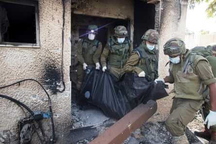 Four soldiers remove a closed body bag out of a building