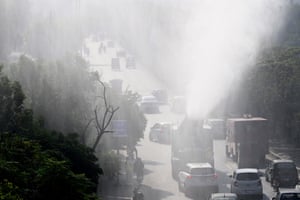 A truck sprays water into the air on a busy street
