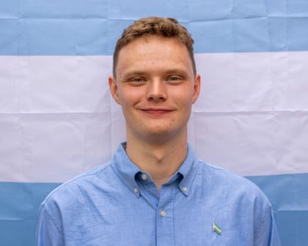 Portrait of Daniel Jackson stood in front of Verdis’s national flag