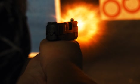 A person firing a gun at a range