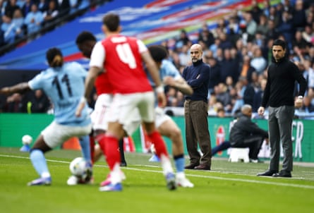 Arsenal manager Mikel Arteta (R) and Manchester City manager Pep Guardiola watch from the touchline during the Carabao Cup final
