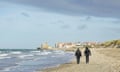 File photo of two French police officers walking with their backs to the camera at the beach in Wimereux near Calais