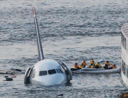people on an inflatable raft in a river next to a half-submerged airplane