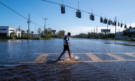 A person walks through a flooded street