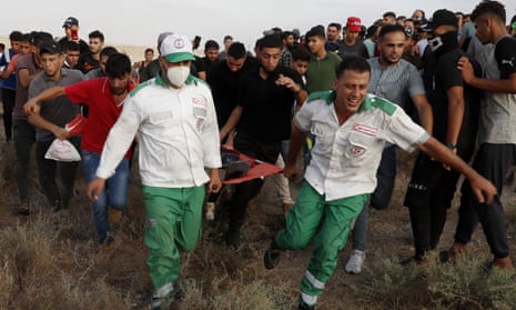 Medics evacuate a wounded person from the fence of the Gaza Strip border with Israel on 21 August.