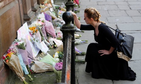 A woman lays flowers for the victims of the Manchester Arena attack, in central Manchester, Britain May 23, 2017. REUTERS/Darren Staples