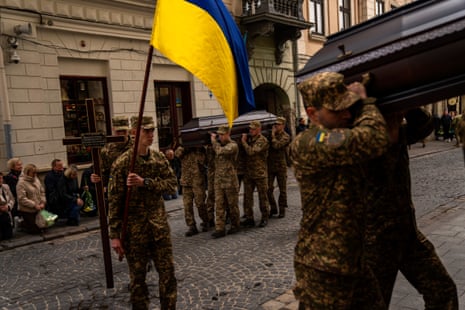 Soldiers carry a Ukrainian flag and the coffins of two Ukrainian army sergeants, Tomkevych Mykhailo and Kril Olexander, during their funeral at the Saints Peter and Paul church in Lviv, Ukraine, on Tuesday.