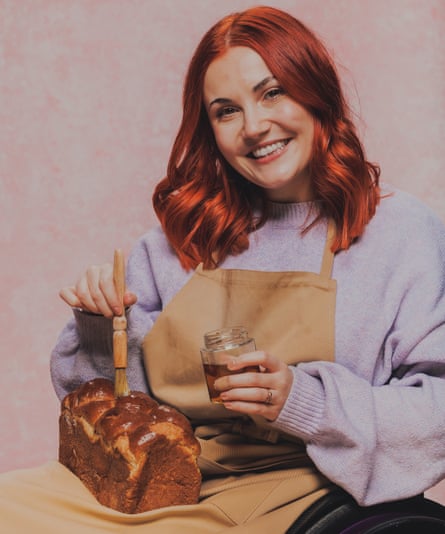 A red headed woman coats a bake with some liquid.