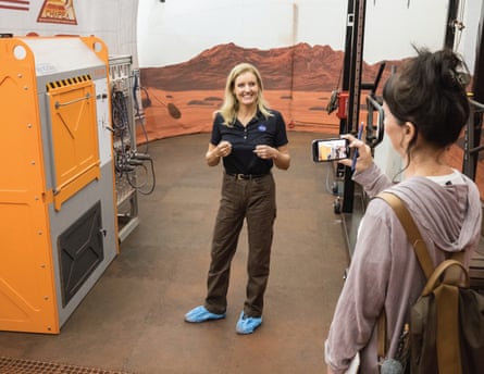 A woman shows off equipment to another woman.
