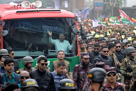 a man waves from a vehicle amid crowds