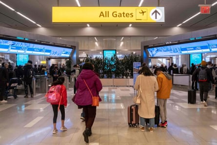 people walk with bags under sign that says 'all gates'