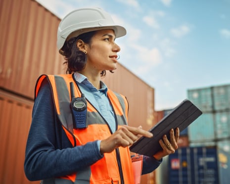 Industrial Engineer in White Hard Hat, High-Visibility Vest Working on Tablet Computer