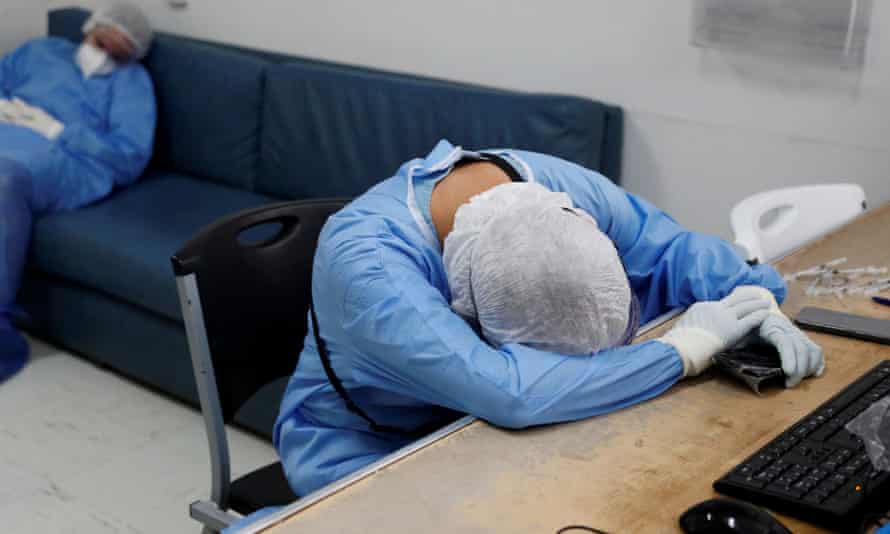 Medical workers in protective suits rest after hours of treating patients in Mexico City, in October.