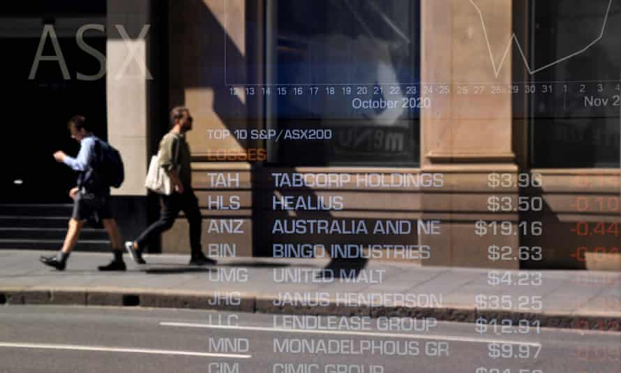 Pedestrians are reflected in a window of the Australian Securities Exchange (ASX) in Sydney on November 9, 2020.