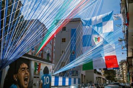 An image of Napoli legend Diego Maradona is seen amongst club colours on a Naples street.