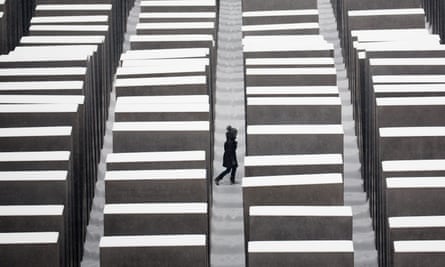A visitor walks through the snow covered Holocaust memorial in Berlin