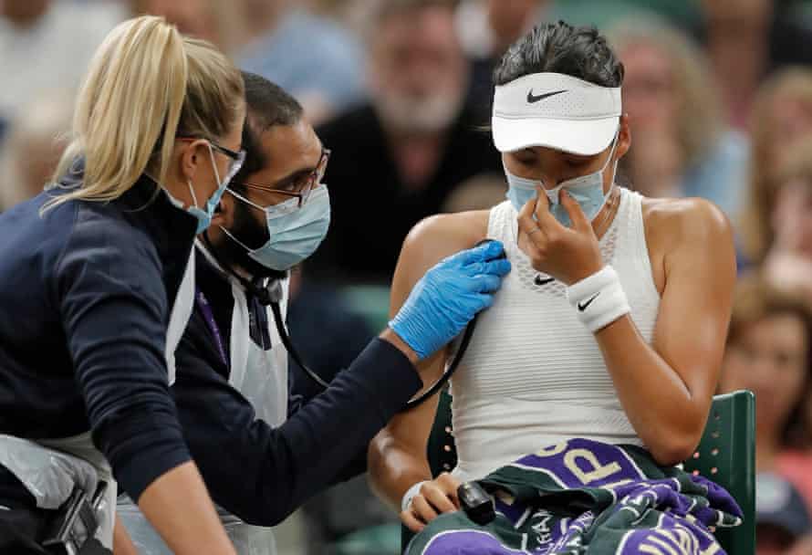 Emma Raducanu of Great Britain is checked by a doctor before going off court and retiring from her match with Alja Tomljanovic on Court One during day seven of Wimbledon 2021 at the All England Lawn Tennis Club on July 5th 2021.