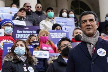 Ydanis Rodriguez, New York City councilmember, stands on the steps of city hall in front of a crowd holding signs advocating for immigrant voting rights.