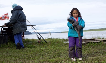 Mary Demientieff Junior, great-granddaughter of an Athabascan elder, holds a silver salmon at their fish camp.