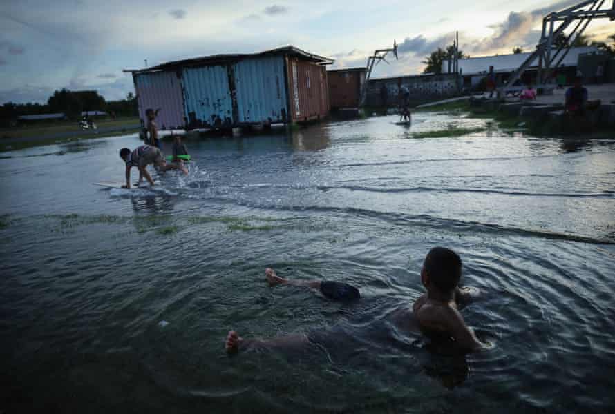 Boys play in floodwaters in Funafuti, Tuvalu. The archipelago is vulnerable to rising sea levels.