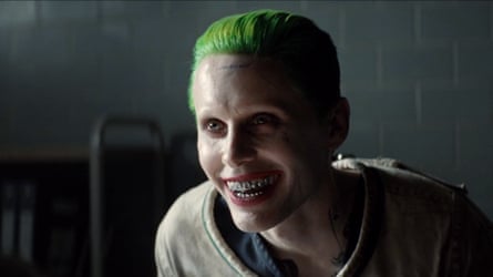 Leto with green hair, leering and showing the metal braces on his teeth