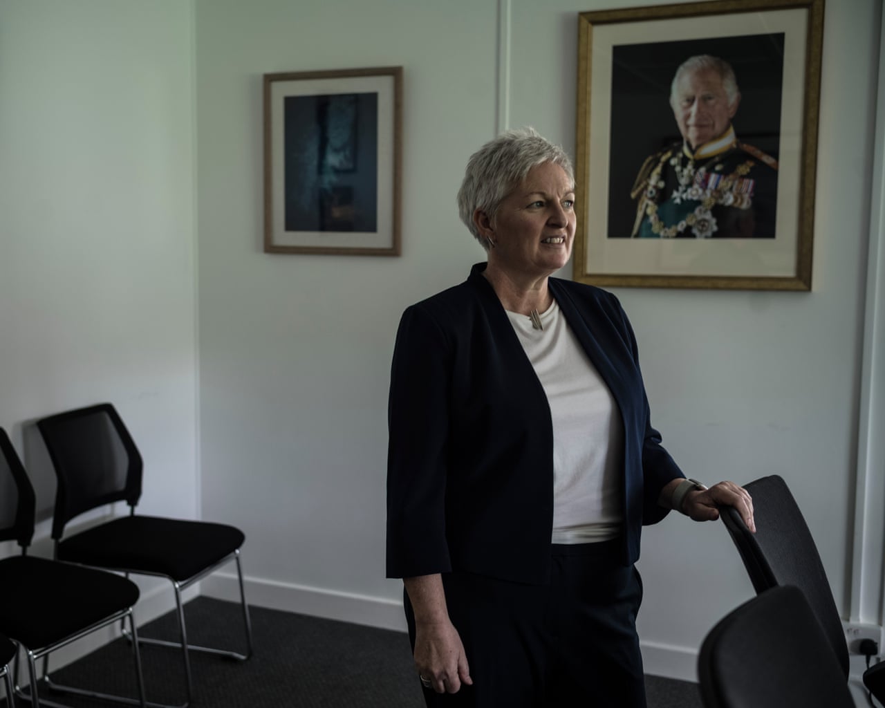 Clausen stands in a room with paintings on the wall, one of which is of King Charles