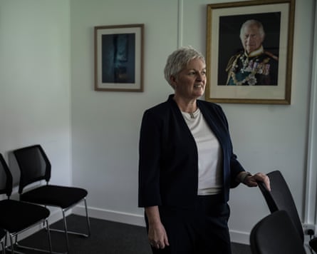 Clausen stands in a room with paintings on the wall, one of which is of King Charles
