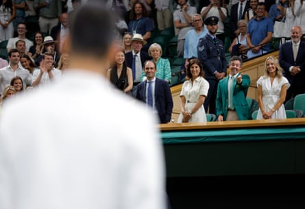 Rory McIlroy, in the Royal Box wearing his Masters Green Jacket, gestures to Novak Djokovic