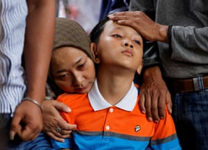Bandung, Indonesia: Siti Sarah and Al Fikri Ibnu Sofyan, wife and the third son of Agus Sofyan, a police officer who was killed in a suspected suicide bombing at a district police station, mourn during his funeral