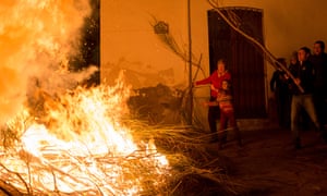 Villagers throw fuel onto a fire in Spain during Antonio Abad festival