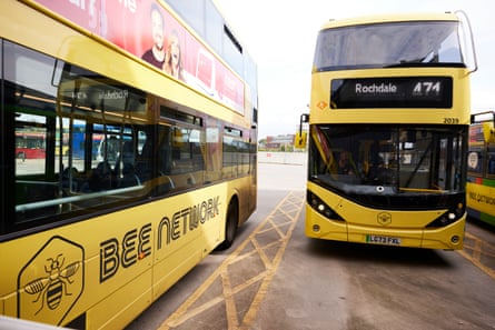 Two yellow buses with Bee Network printed on their side