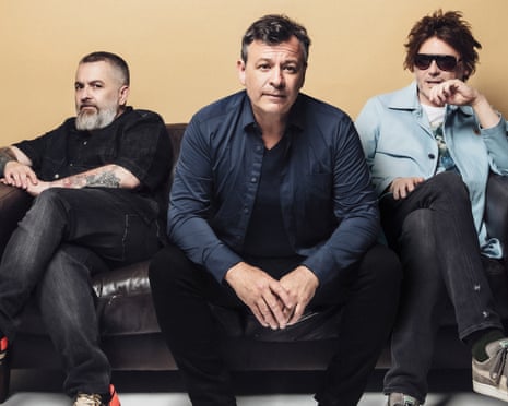 Sean Moore, James Dean Bradfield and Nicky Wire of Manic Street Preachers sitting on a sofa