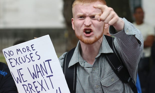 A man carrying an anti-EU pro-Brexit placard shouts in a counter protest against pro-Europe marchers