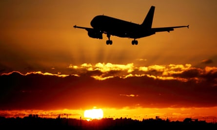 A plane lands as the sun sets at Heathrow.