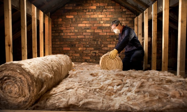 A man puts insulation in his loft.