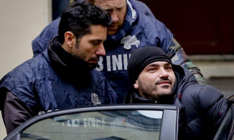 Alessandro Giannelli is bundled into a police car after his arrested as part of a swoop on a mafia clan.