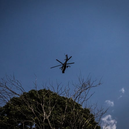 A military helicopter flies overhead