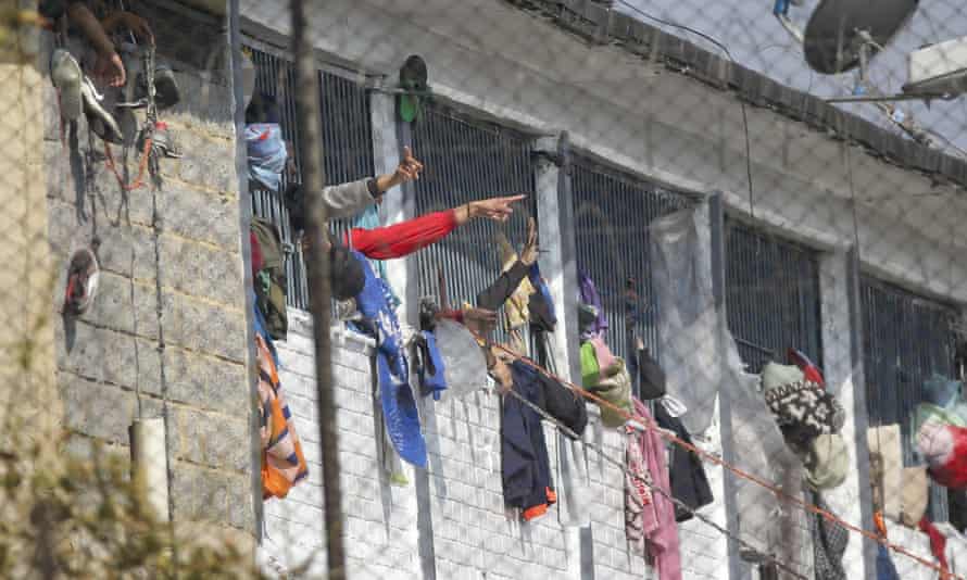 Inmates at La Modelo jail in Bogotá, Colombia, gesticulate from their cell windows