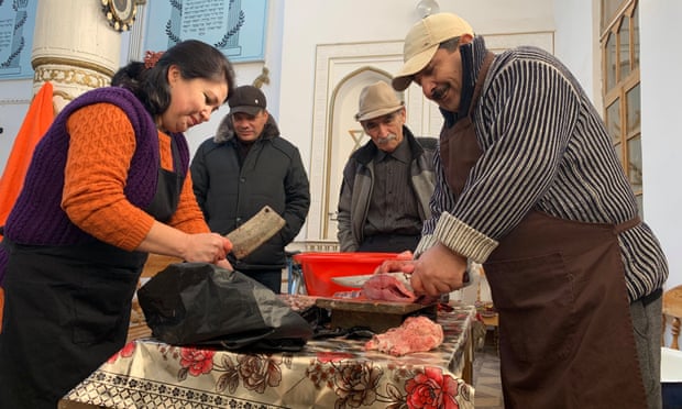 Sofi Asadov and his wife Delfuza prepare fish for a Hanukah celebration.