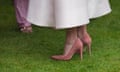 Close up of pink suede shoes with plastic heel protectors on a lawn
