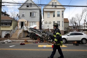 New Jersey, USA fireman walks past the wreckage of a light aircraft which crash landed in a residential street in Bayonne, New Jersey