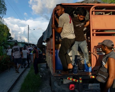 Volunteer Eduardo Perozo jumps from the back of a truck at the Guedez García family home
