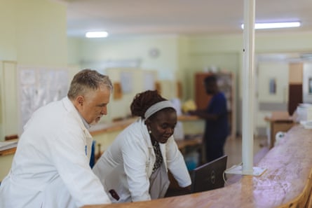 A male and female doctor looking at a computer screen at a hospital desk